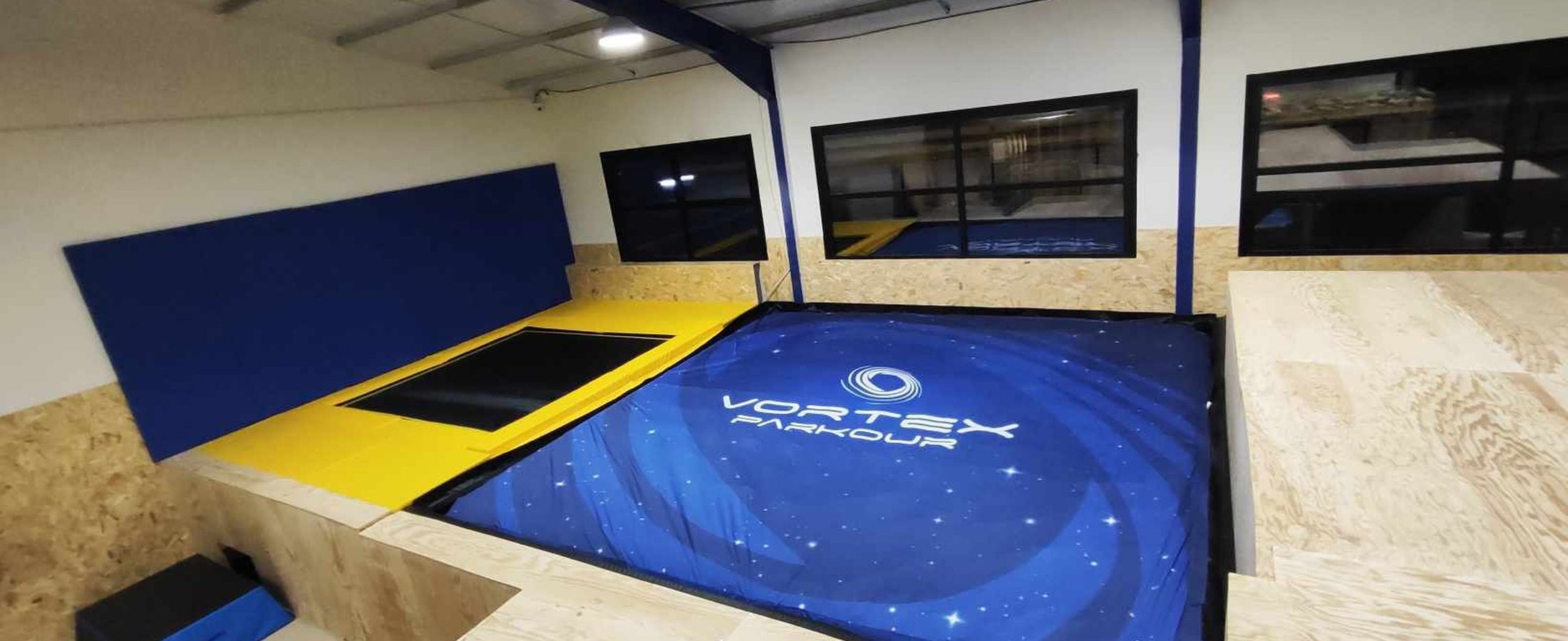 Intérieur de la salle Vortex Parkour avec le grand airbag floqué du logo
